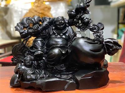 Tượng Phật Di Lặc gỗ Mun Sừng Khánh Hòa liền khối, ngồi gánh Đào Tiên trên núi vàng, bao tiền. Ý nghĩa phong thủy chiêu tài lộc, may mắn, phú quý